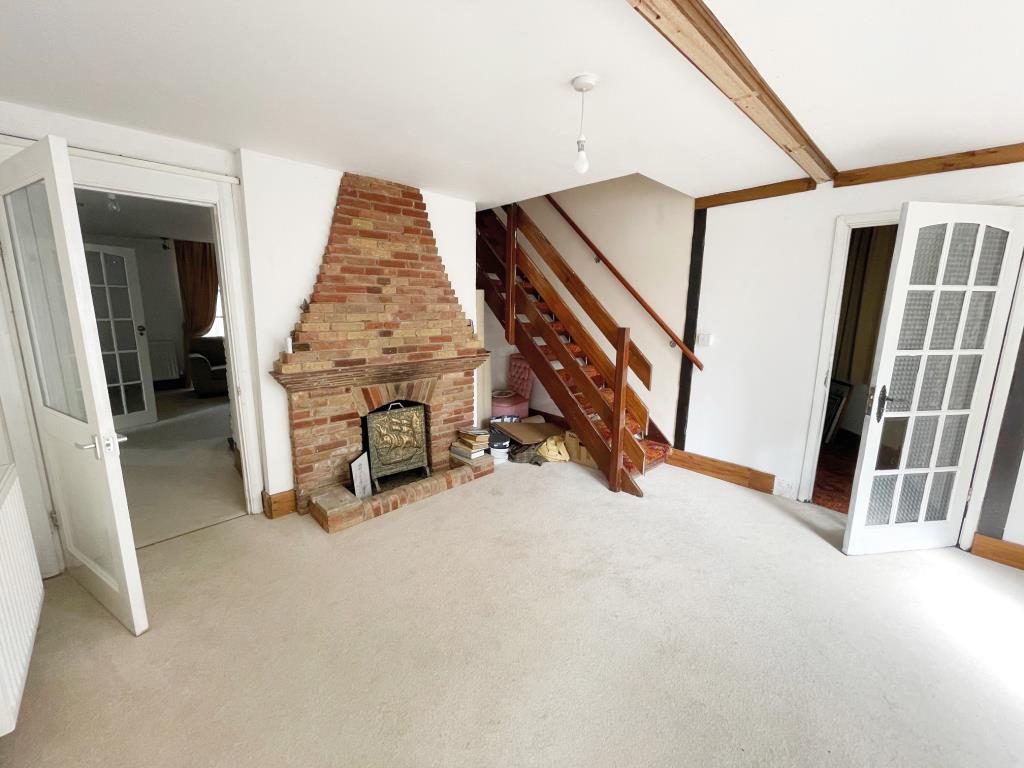 Lot: 106 - DETACHED FORMER GATEHOUSE FOR IMPROVEMENT - Reception room with fireplace and stair to first floor